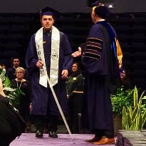 TIRR Memorial Hermann patient, Dallas Matamoros, walks down the aisle at his graduation from LSU.